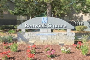 Renwick Square stone sign, "Senior Rental Community" surrounded with mulch and flowers